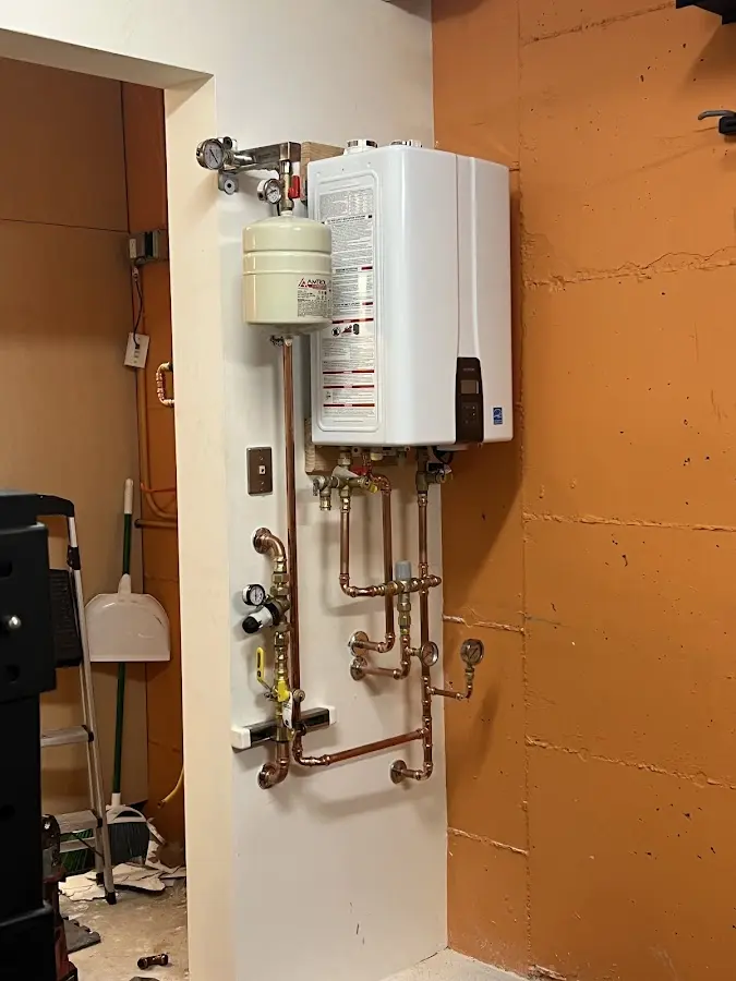 Plumbing technician inspecting water heater connections in Hartwell